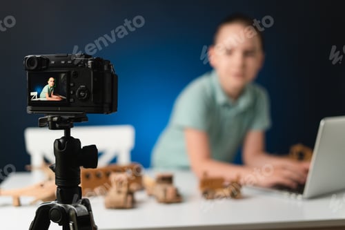 Preview: Young guy streaming for his fans. Boy explaining in front of camera using laptop. Generation Z