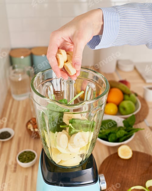 Preview: Raw green smoothie drink. Woman preparing morning breakfast for vegan, vertical