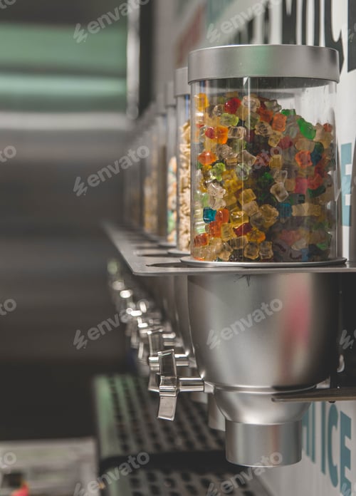 Preview: Vertical shot of colorful gummy candies inside of a dispenser