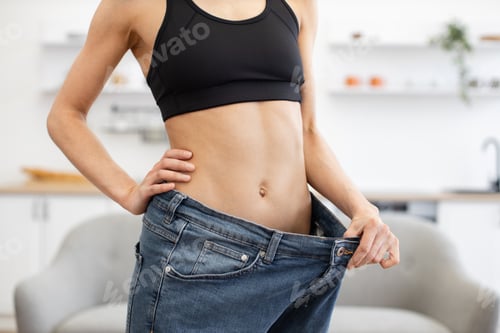 Preview: Person showing significant weight loss with oversized jeans