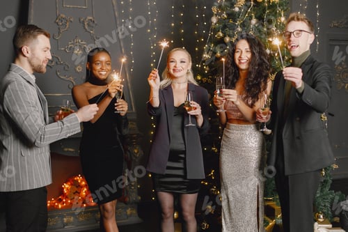 Visualização: Amigos masculinos e femininos em vestidos elegantes comemorando o Ano Novo