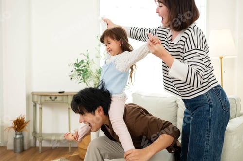 Preview: Parents playing together with their daughter in the living room