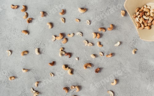 Preview: flat lay with arranged cashews and bowl on grey surface
