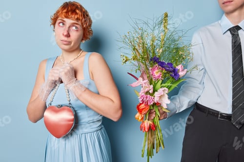 Preview: Horizontal shot of redhead lady with thoughtful expression wears dress and lace gloves holds heart