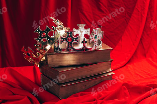 Preview: ancient golden and silver crowns with gemstones on books on red cloth