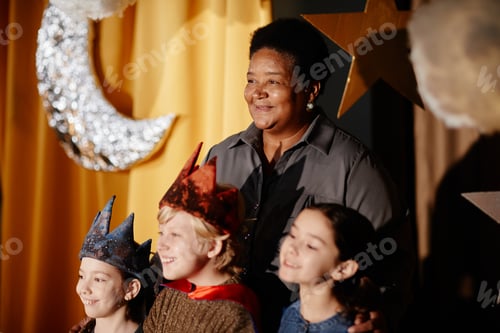 Preview: Smiling Teacher with Students on Stage in Costumes