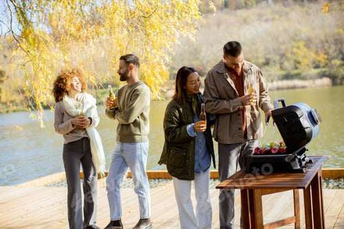 Preview: Friends gather for a joyful barbecue by the serene lakeside, enjoying food and drinks in autumn