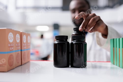 Preview: African american pharmacist taking medication from drugstore shelf closeup