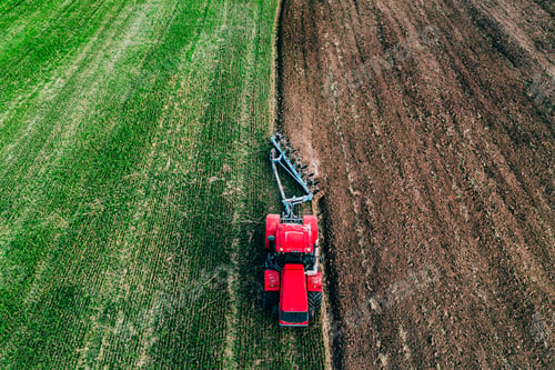 Preview: Aerial view of farmer tractor ploughing in field