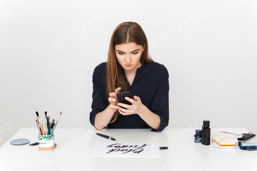 Preview: Woman Using Smartphone While Working at Desk