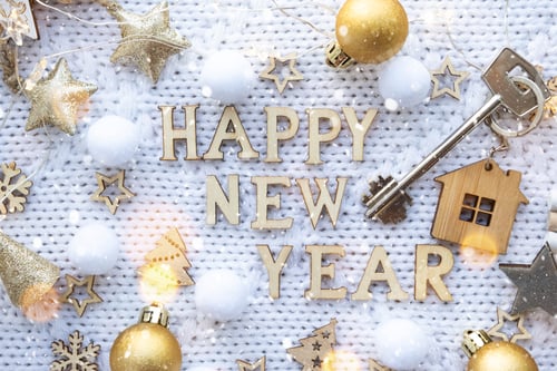 Preview: House key with keychain cottage on a festive knitted background with sequins, stars, lights of garla
