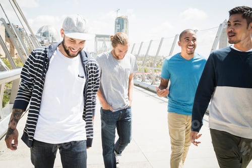 Preview: Group of young men walking along a bridge.