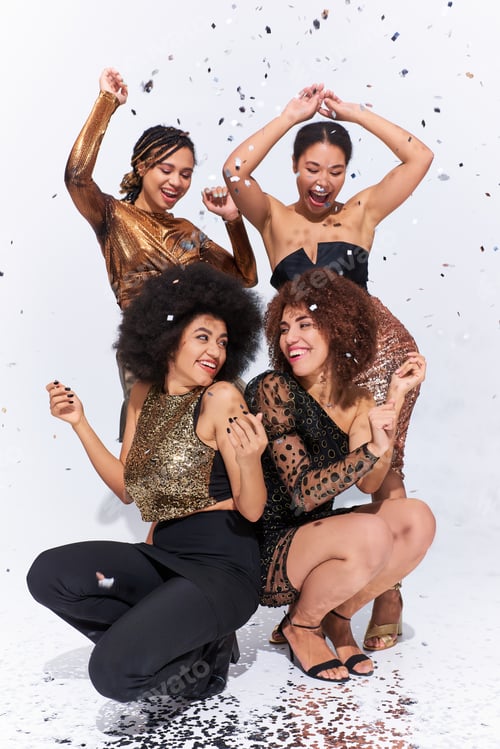 Preview: stylish attractive african american women partying under confetti rain sitting on floor, fashion