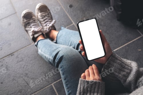 Preview: a woman holding black mobile phone with blank desktop screen