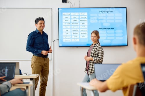 Preview: High school teacher and female student using interactive whiteboard on a class in the classroom.