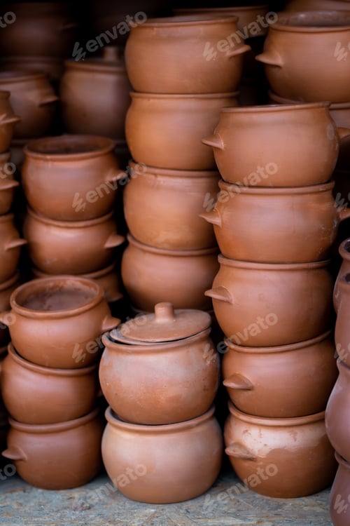 Preview: Stocks of various terracotta and brown pots for plants or cooking for sale on counter at shop.