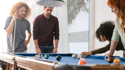 Preview: Man aiming cue stick on billiard ball while playing pool with friends at home