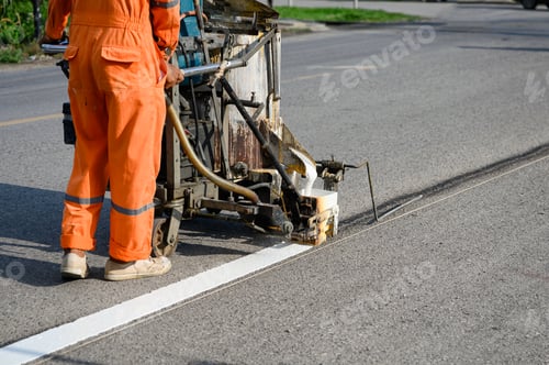 Preview: Worker wearing uniform is making the white line on road with painting machine