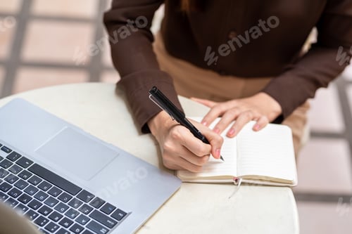 Preview: Image of a businesswoman holding a pen and taking notes on work concept.