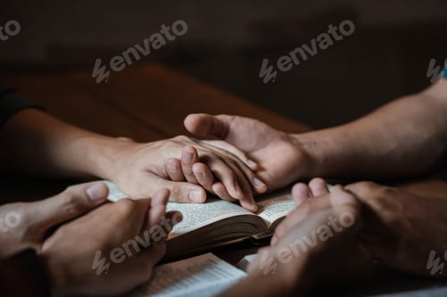 Preview: A group of young Christians holding hands in prayer for faith