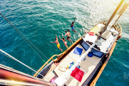 Preview: Aerial view of young people jumping from sailing boat on sea trip