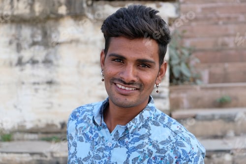 Preview: Portrait of a young smiling Indian male standing outdoors