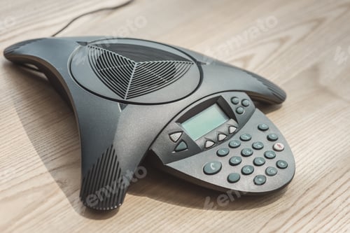 Preview: close-up shot of speakerphone on wooden table at office