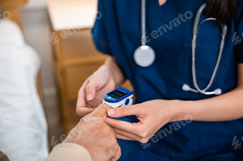 Preview: Young woman putting digital oximeter of finger middle aged adult patient man
