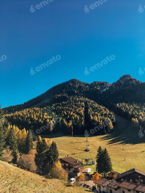 Preview: Natural background, blue sky, green forest and field, old little village in mountains, autumn