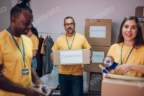 Preview: Group of multiracial volunteers working in community charity donation center