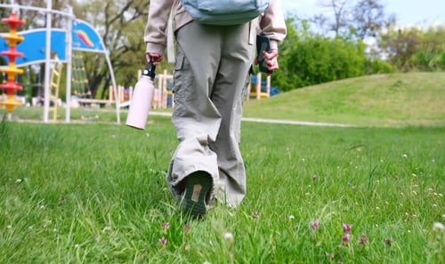 Preview: Little Girl Walking In Summer Park After School Lessons, Feet Tread On The Grass