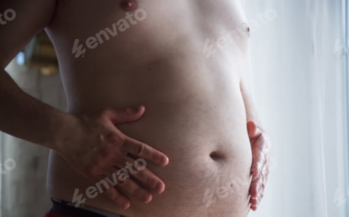 Preview: guy holding his fat in hand and stay near window