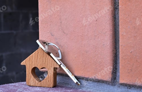 Preview: a key with a keychain in the form of a house with a heart on the background of the finished year of