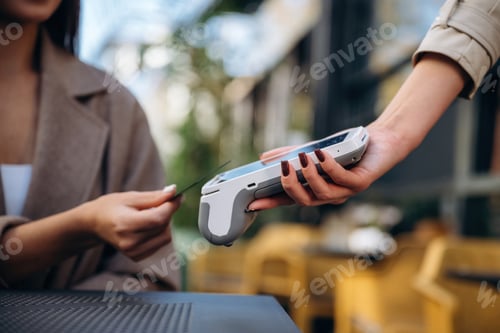 Preview: Woman is paying for food in cafe by using credit card. Conception of wireless money transfer