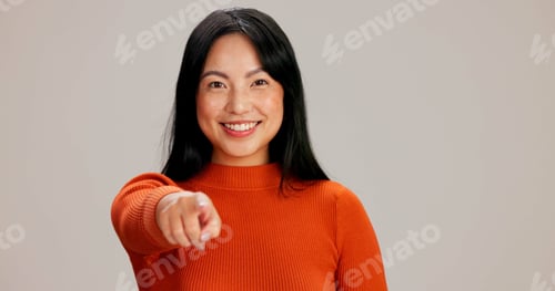 Preview: Asian woman, portrait and point at you studio with smile, choice and hiring by background. Girl, pe