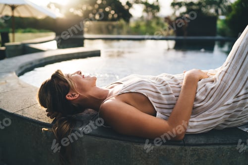 Preview: Woman lying and resting on swimming pool edge