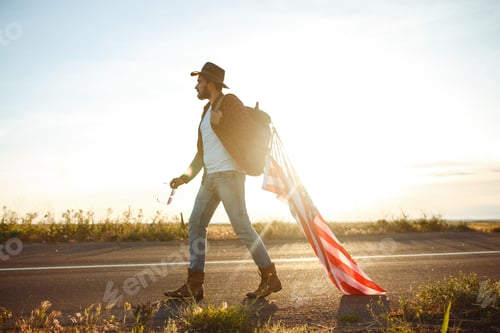 Preview: 4th of July. American Flag.Patriotic holiday. Traveler with flag of America. Beautiful sunset light