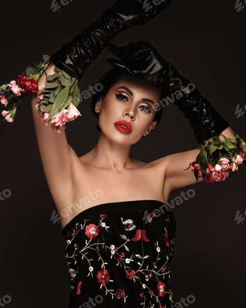 Preview: Beautiful brunette woman iwith a classic make-up, red lips, holding flowers. The beauty of the face.
