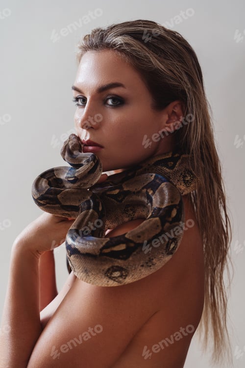 Preview: Beautiful woman with python snake elegantly slithering over her neck