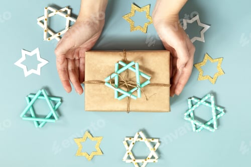 Preview: Jewish holiday Hanukkah. A gift and symbol of Hanukkah star of David on a blue background. Top view