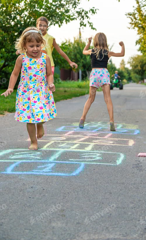 Preview: Children jumping hopscotch on the street. Selective focus.