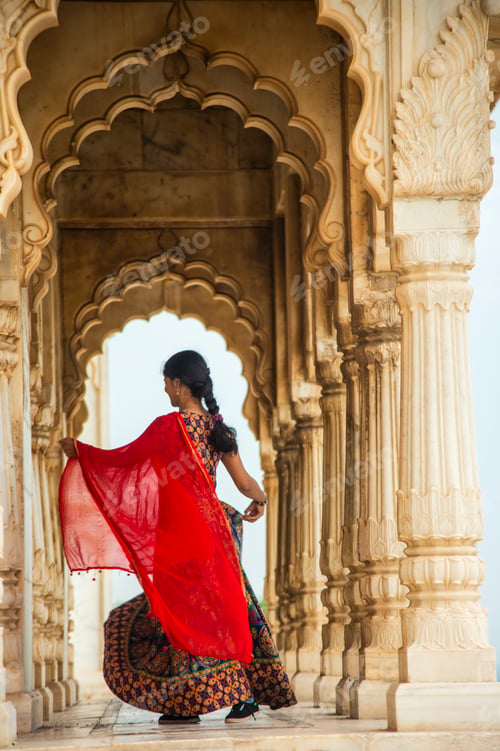 Preview: Young female tourist dancing between arches and Pillars.