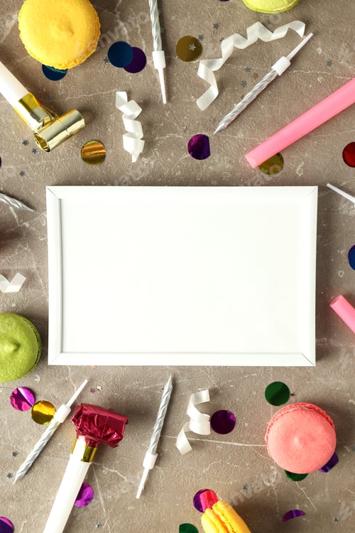 Preview: Birthday accessories and empty photo frame on gray textured table, space for text