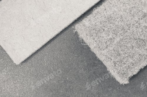 Preview: Grayscale shot of compressed thermal insulating hemp fiber panels on a rough-textured surface