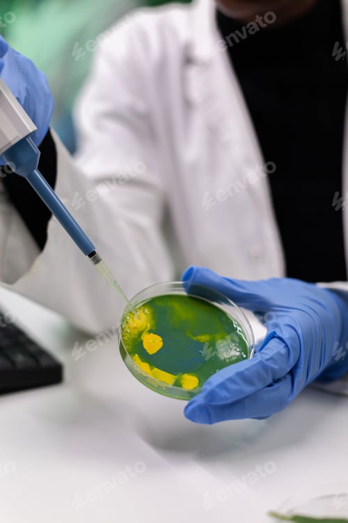 Preview: Closeup of african american biologist scientist dropping liquid using medical micropipette