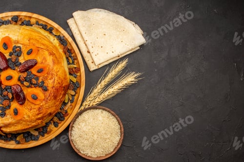 Preview: top view shakh plov delicious rice meal cooked inside round dough with raisins on grey background
