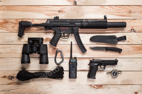 Preview: Assault rifle, gun, knife with sheath, compass and notebook with pen on table.