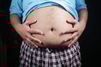 Vorschau: Mann zeigt Bauch, während er drinnen in Freizeitkleidung posiert