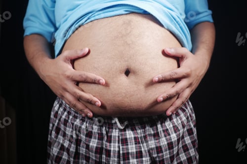 Preview: Man showing belly while posing in casual attire indoors