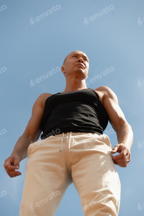Preview: Portrait of athletes man or sports trainer against sky. Outdoors.